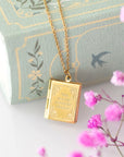 Colgante relicario de libro dorado
