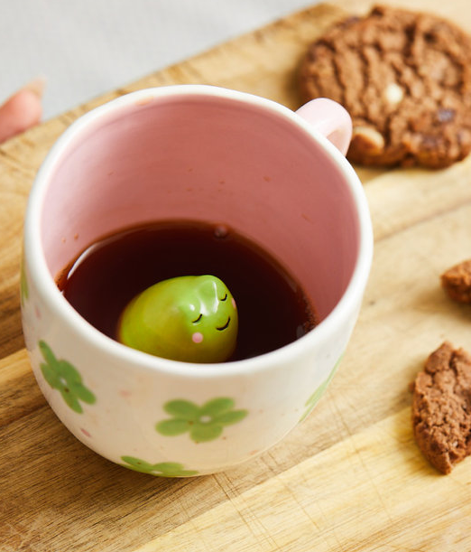 Taza con figurita de rana en el interior