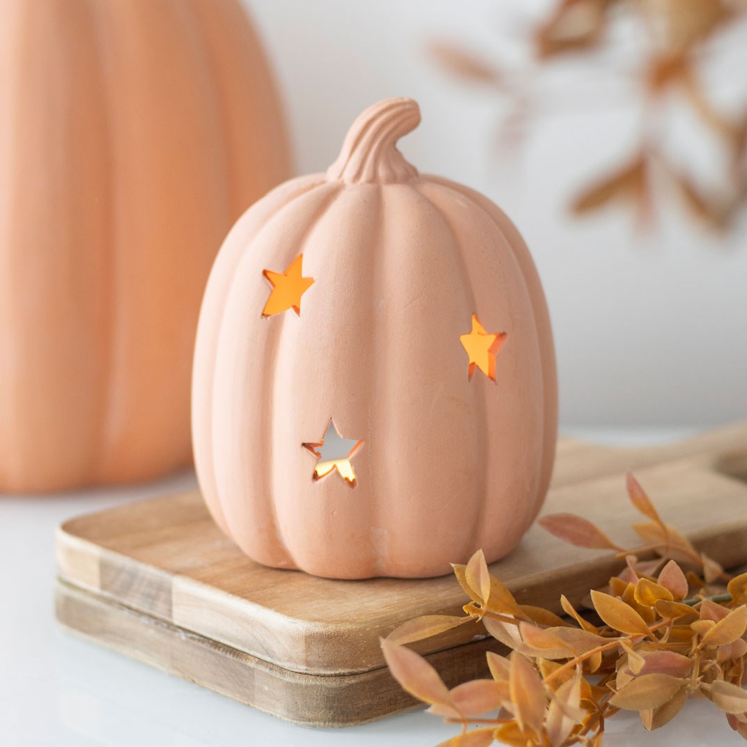 Portavelas de terracota naranja con forma de calabaza y estrellas